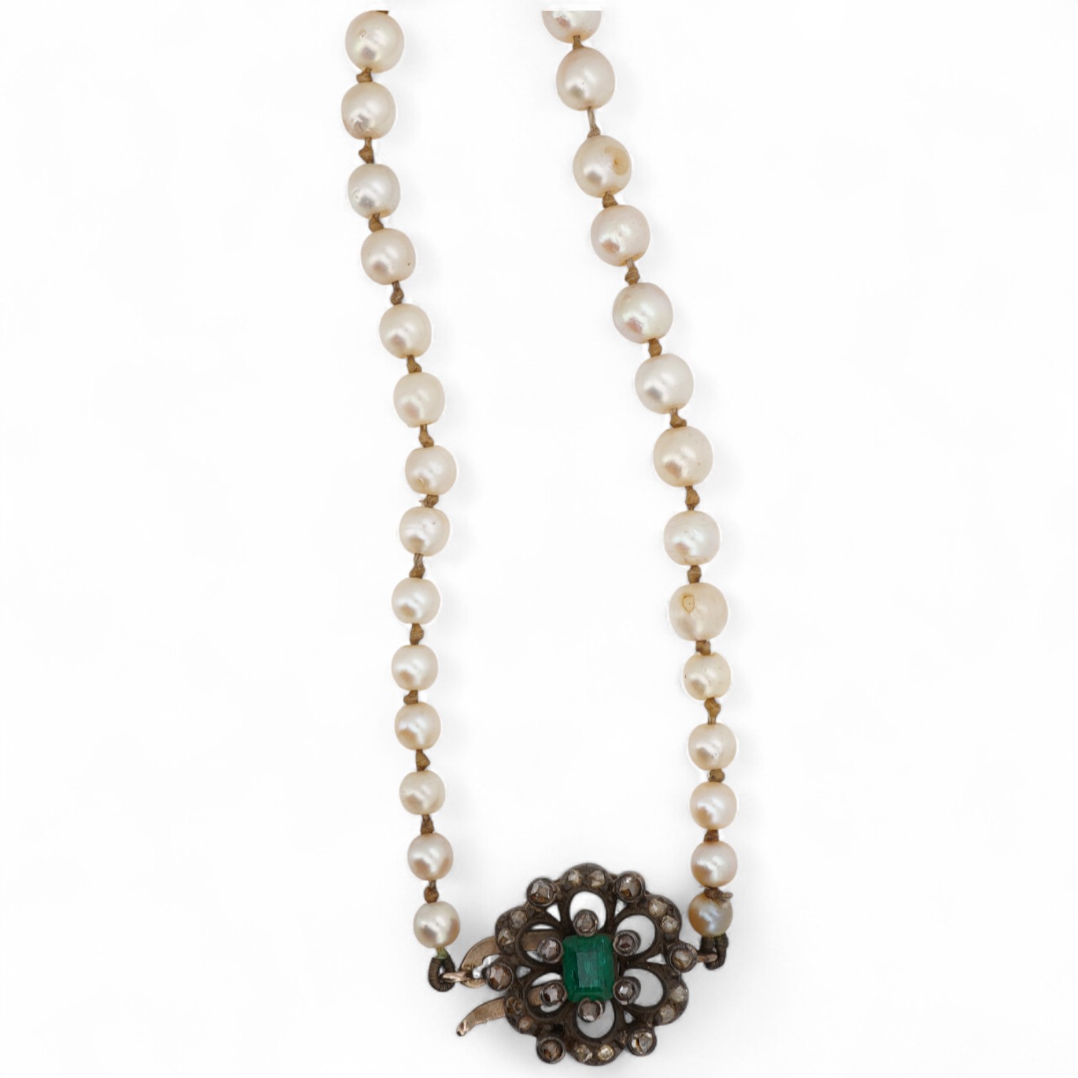 A single strand graduated cultured pearl necklace, with a single stone emerald and rose cut diamond cluster set yellow metal clasp, 64cm.